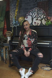 Portrait of young femal artist sitting in front of piano