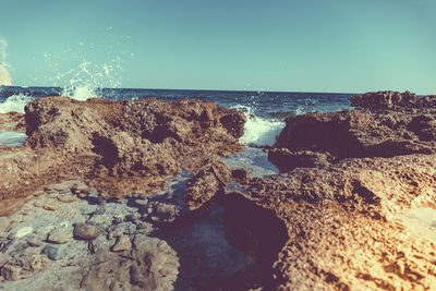 Close-up of rocks on beach against clear sky