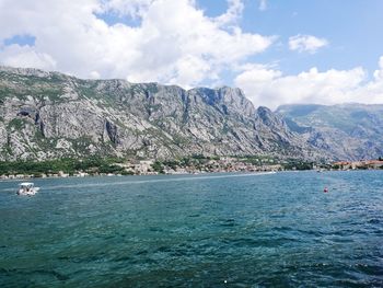 Scenic view of sea and mountains against sky