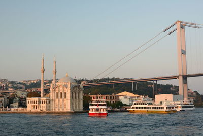 Sailboats in river against buildings