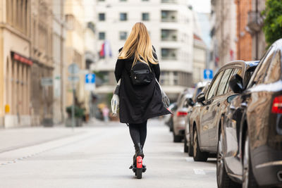 Rear view of woman walking on street in city