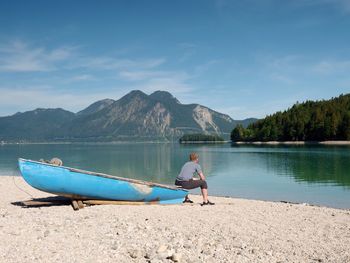 Sports boats, blue green mountain lake, windless summer day.