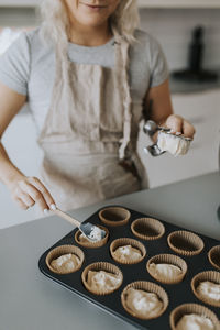 Woman in kitchen preparing cupcakes