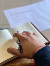 Close-up of hand holding book on table