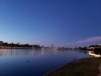 Scenic view of lake against blue sky at sunset