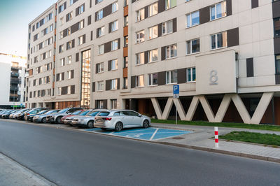 Cars parked on street by building in city