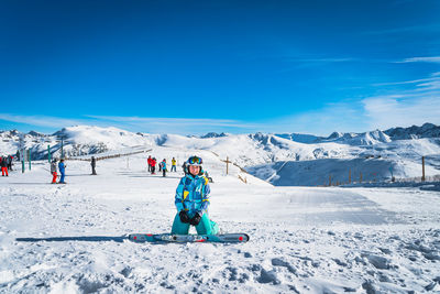 Portrait of woman skier looking at camera with people skiing on the back pyrenees mountains andorra