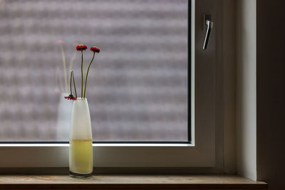 Close-up of glass window on table against wall