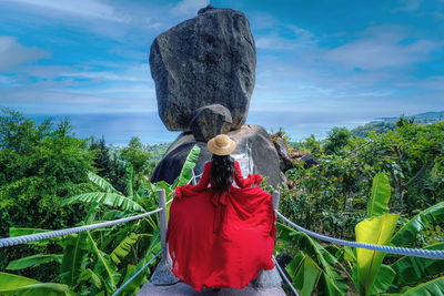 Asian woman tourist in red dress sightseeing  the view of overlap stone at koh samui in thailand