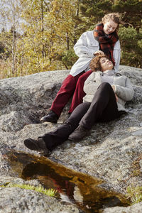 Female couple relaxing on rocks