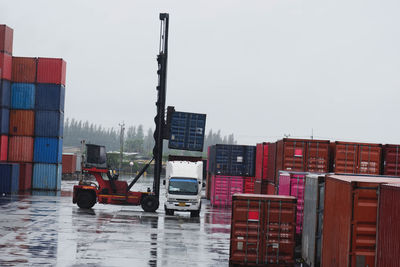 Container forklift moving containers into trucks