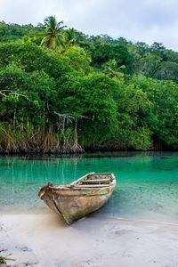Boat moored on beach against sky