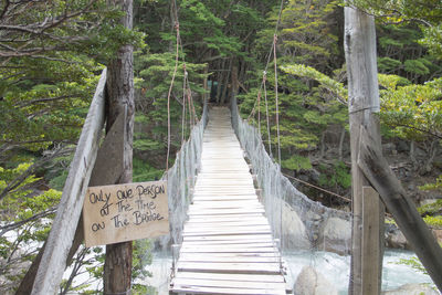 Information sign on footbridge in forest