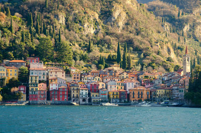 Scenic view of townscape by river in city