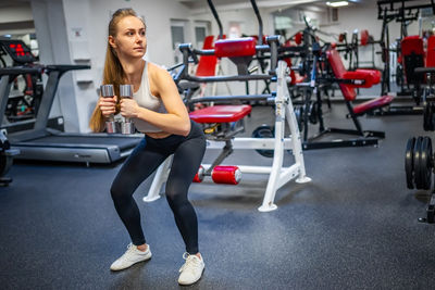 Full length of woman exercising in gym