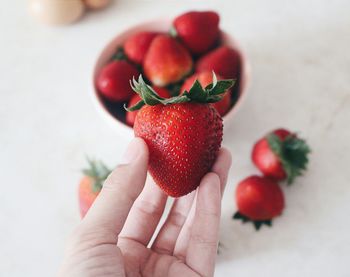 Persons hand holding strawberry