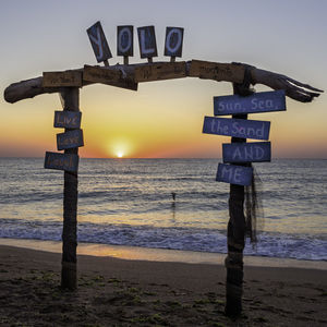 Door on the beach against sky during sunset