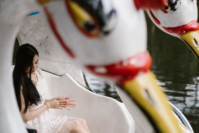 Young woman sitting on outdoor play equipment