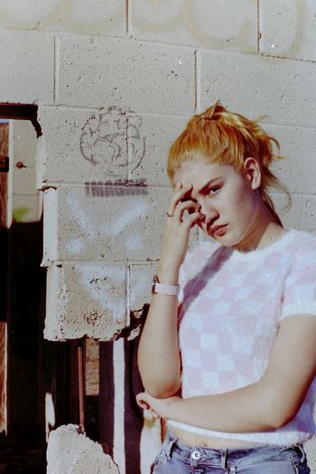 Portrait of woman standing against wall