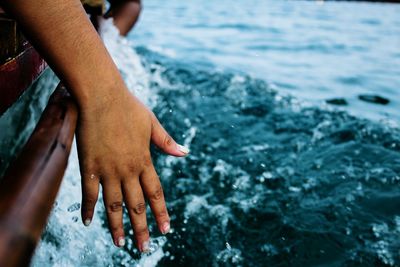 Cropped hand in boat on sea