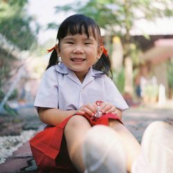 Portrait of smiling girl sitting outdoors