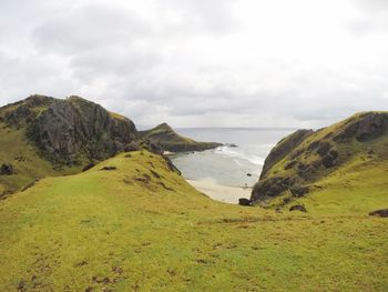 Scenic view of sea and mountains against sky