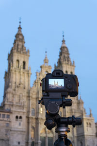 Dslr photo camera with digital display showing the santiago de compostela cathedral at dusk.