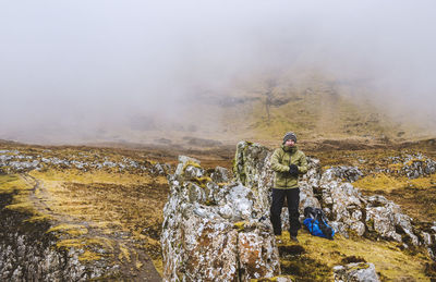 Full length of man hiking on quirang hill during foggy weather