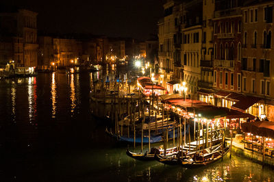 Boats moored in canal at night