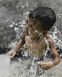 Portrait of shirtless boy in water