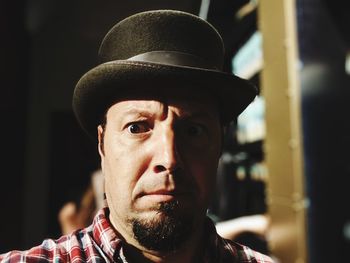 Close-up portrait of shocked man wearing hat at night