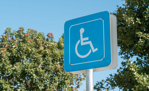 Low angle view of information sign against blue sky