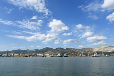 City at waterfront against cloudy sky