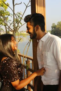 Smiling young couple against lake