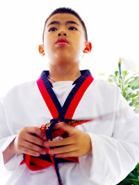 Low angle view of boy wearing sports clothing standing against clear sky