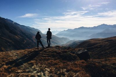 Rear view of men walking on mountain road