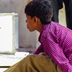 Side view of young man looking away at home