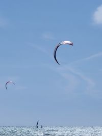 Paragliding over sea against sky