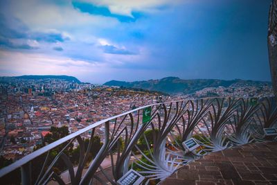 Bridge over river in city against sky