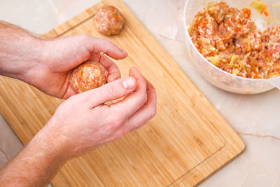 Cropped hand of person preparing food on table