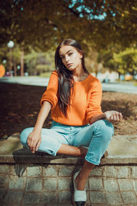 Portrait of beautiful young woman sitting outdoors