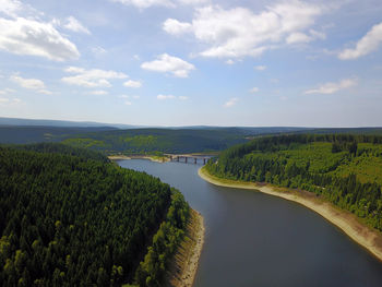 High angle view of river amidst field against sky