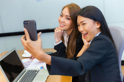 Smiling young woman using mobile phone