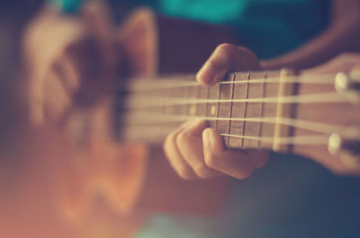 Midsection of man playing guitar