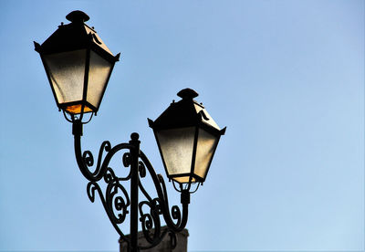 Low angle view of illuminated street light against clear sky