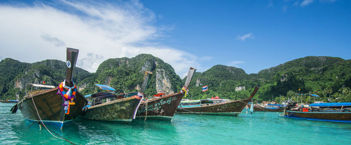 Boats moored in sea against sky