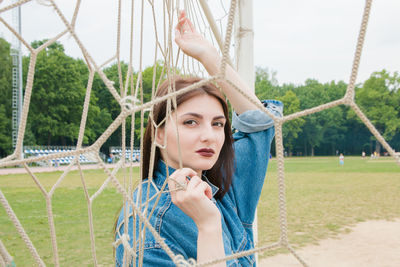 Portrait of young woman looking through net