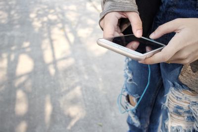 Low section of woman texting on the phone