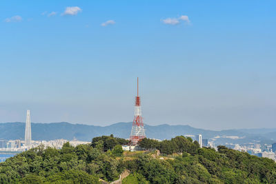 Tower on landscape against blue sky