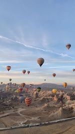 Hot air balloons flying over land